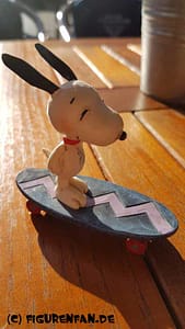 Peanuts Figur Snoopy fährt Skateboard auf dem Tisch