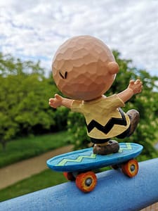Figur Charlie Brown von der Serie Peanuts auf einem Skateboard