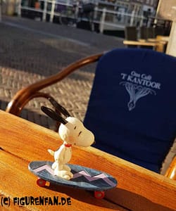 Peanuts Figur Snoopy auf seinem Skateboard auf einem Tisch