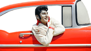 Elvis Figur schaut aus einem roten Auto