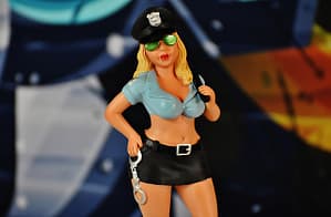 Figur einer sexy Polizistin mit Handschellen in der Hand und knapper bekleidet