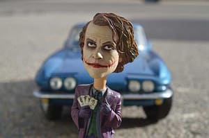 Joker Actionfigur vor Sportwagen