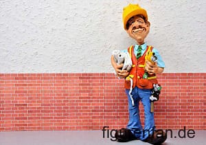 Architekt Figur Funny Job vor Wand mit Messinstrument und Plänen