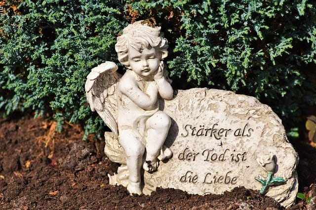 Engel auf einem Grabstein mit Inschrift