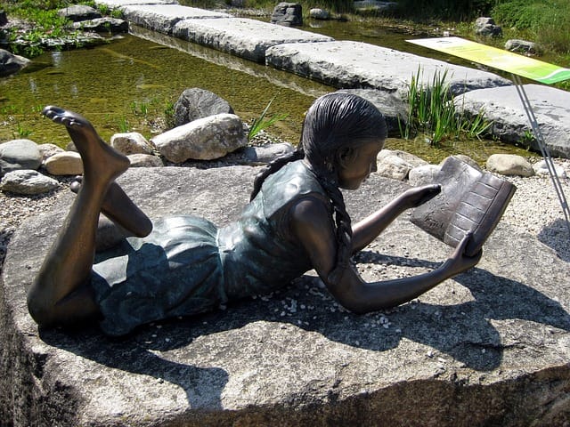 lebensgroße Bronze Skulptur lesendes Mädchen